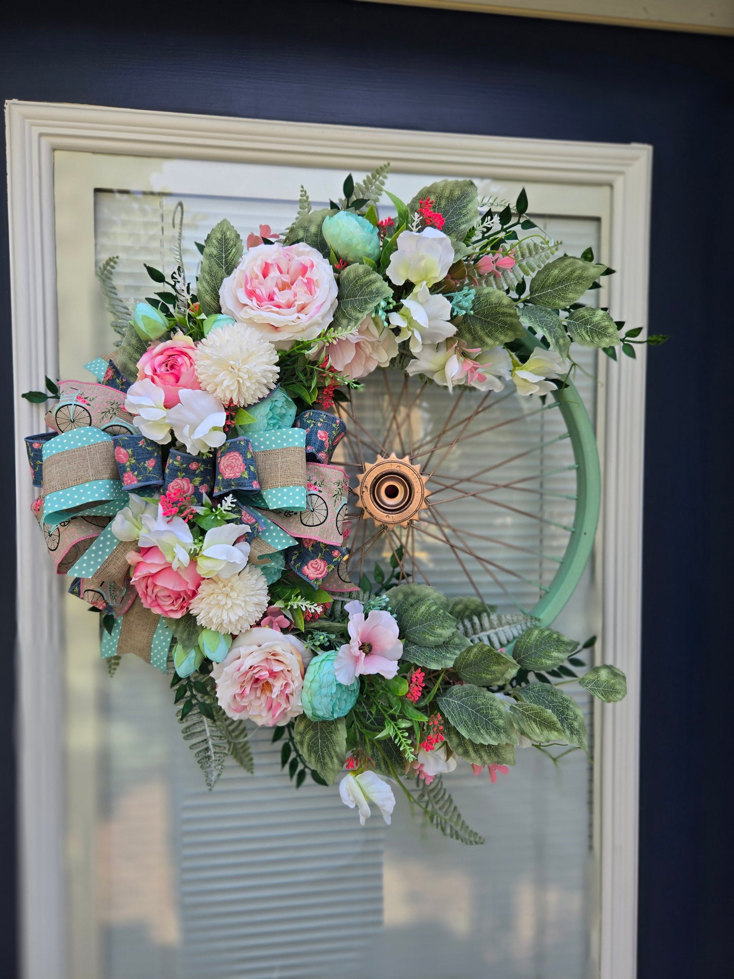 Bicycle wreath with artificial greenery and realistic pink silk flowers
