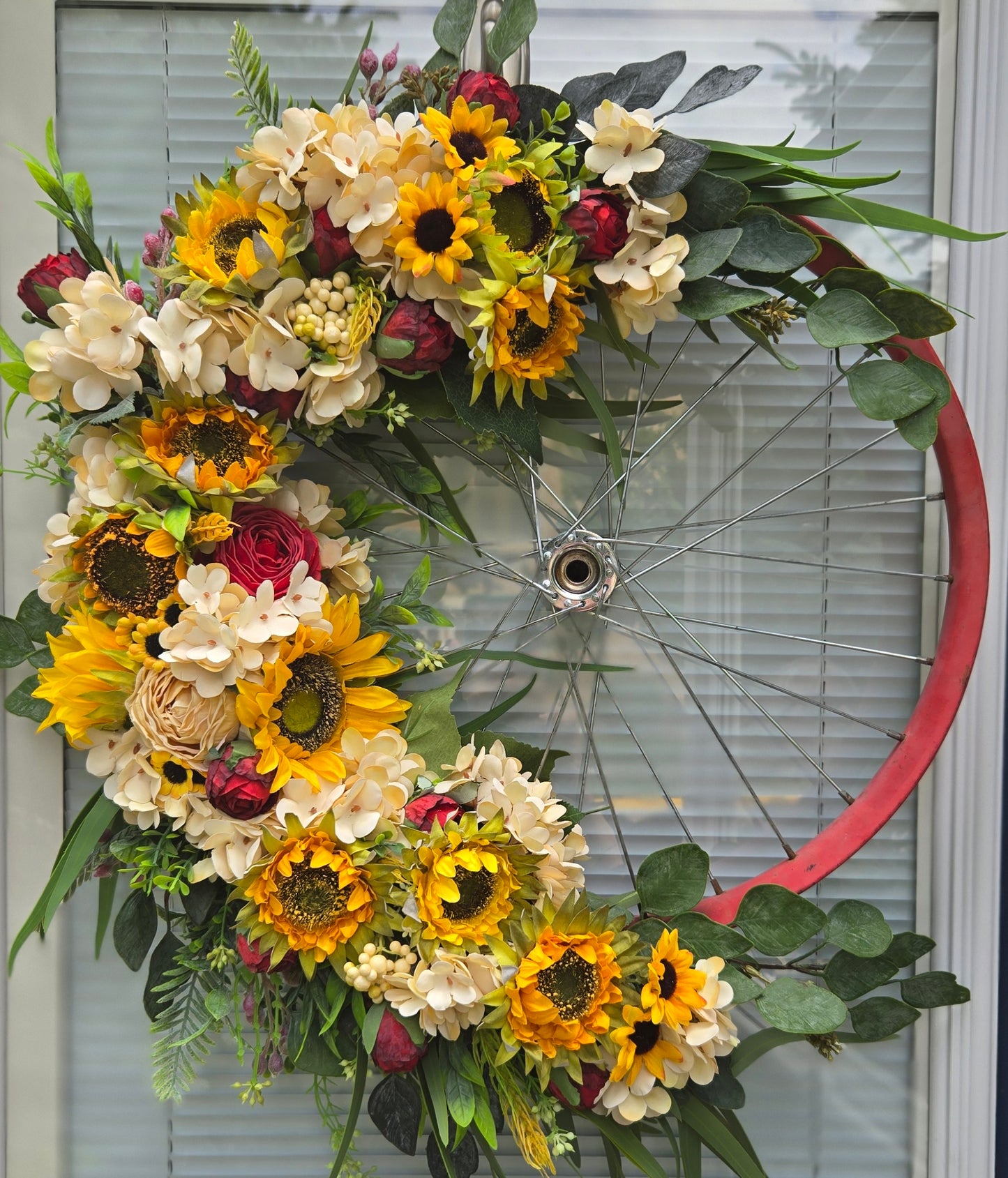 Vintage red bicycle rim and silk sunflowers and roses