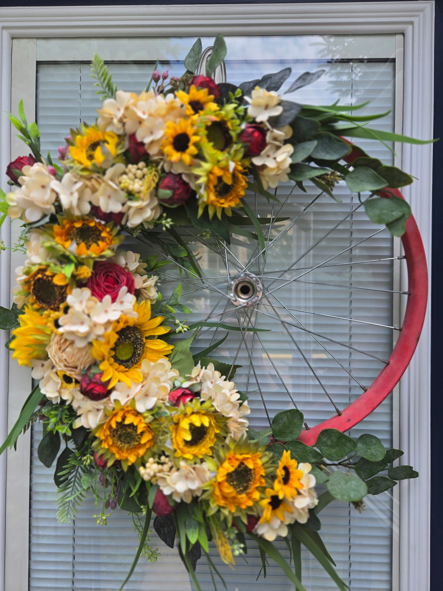 Vintage red bicycle rim and silk sunflowers and roses